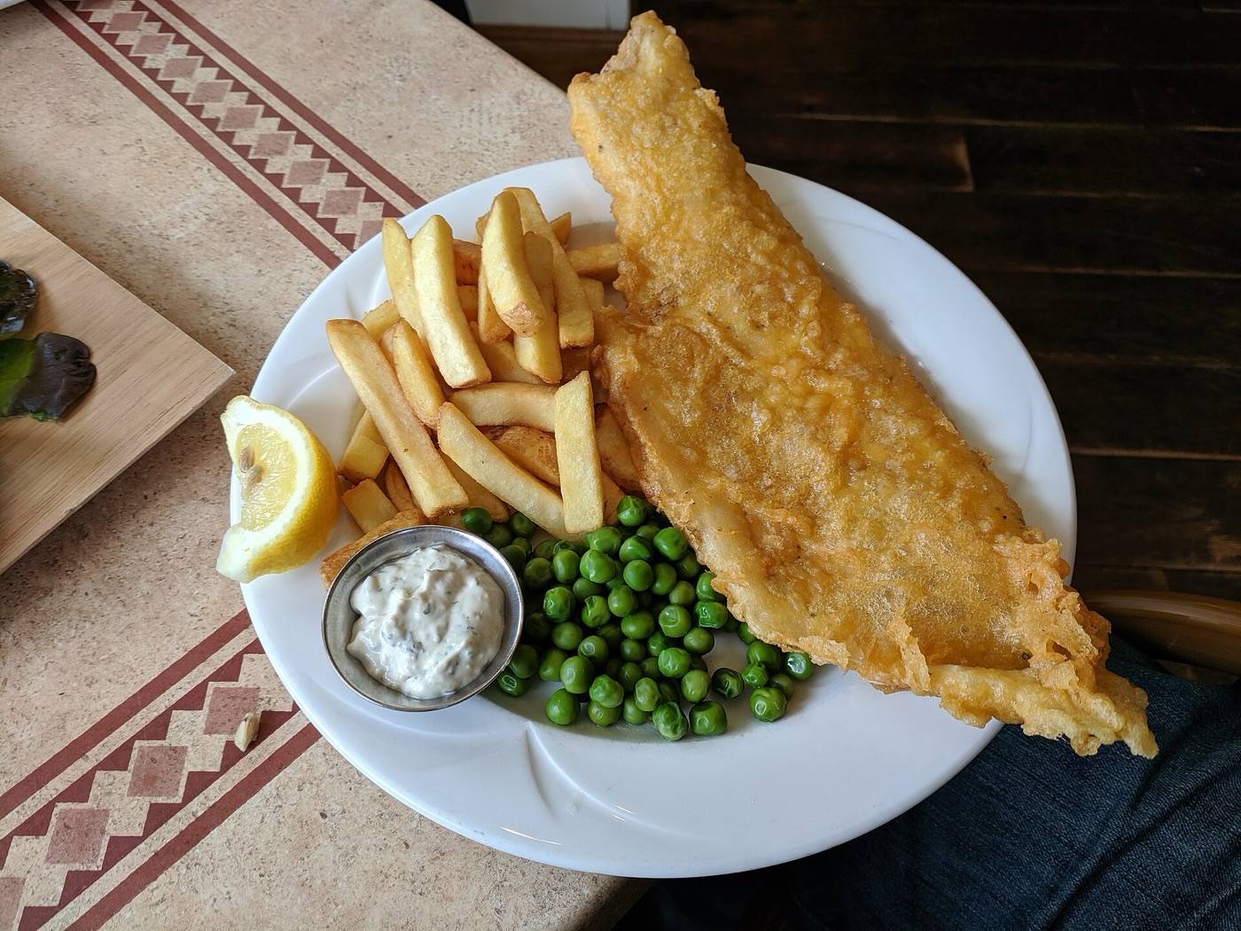 Battered fish, chips and peas on a plate